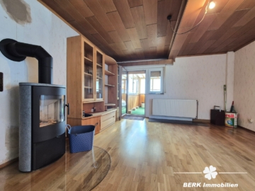 *VERKAUFT* BERK Immobilien – top Wohnlage in Alzenau: Ein- bis Zweifamilienhaus mit Erweiterungspotential & Nebengebäuden - Wohnzimmer mit Kaminofen und Zugang zur überdachten Terrasse (115714)